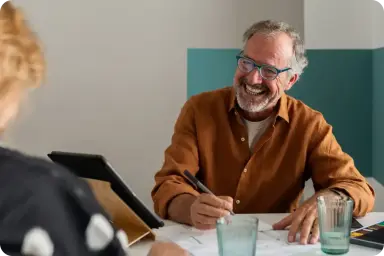 A man writing notes in a client meeting